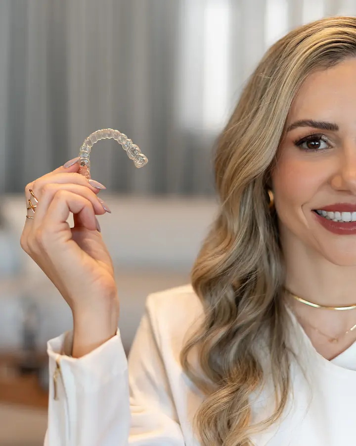 Dra. Alice Freitas mostrando um alinhador Invisalign transparente