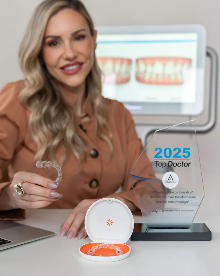 Dra. Alice Freitas segurando um alinhador Invisalign, ao lado do troféu Top Doctor 2025 da Align Technology